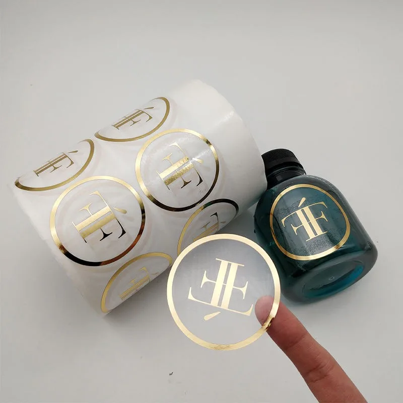 Gold foil monogram logo stickers on clear self adhesive film, manufactured by Labelex